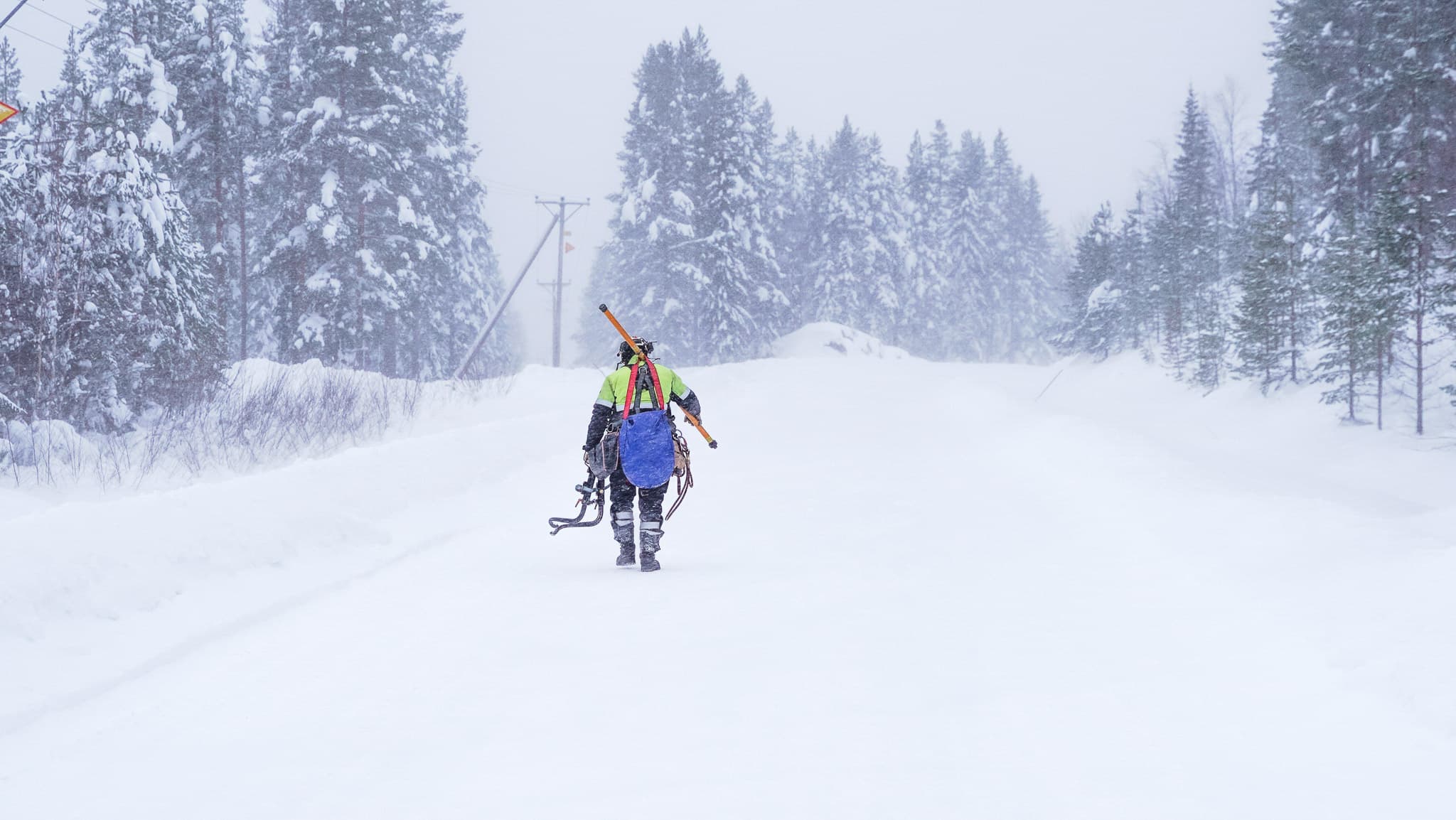 Medarbetare från BTEA går längs en väg i snöoväder med utrusting för att underhålla elledningar i vårt elnätsområde.